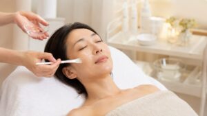 施術ベッドで顔にピーリング剤を塗布される女性